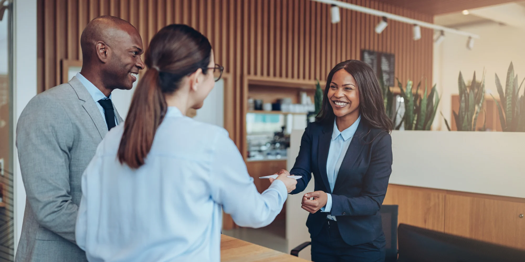 hotel staff checking in smiling guests